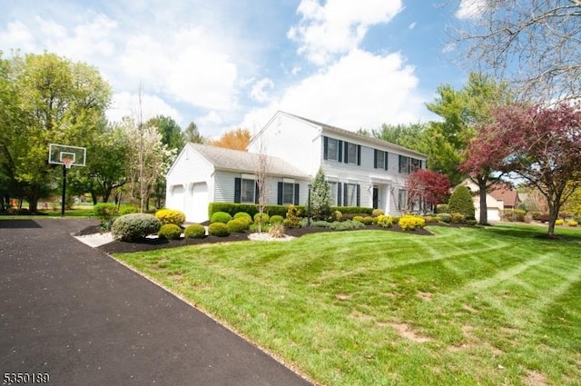 colonial-style house with an attached garage and a front yard