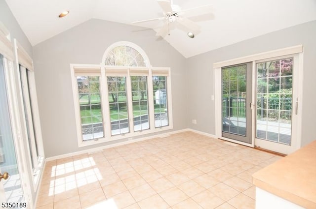 interior space featuring plenty of natural light, ceiling fan, light tile patterned floors, and vaulted ceiling