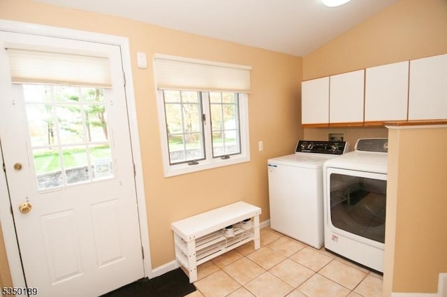 washroom with cabinet space, baseboards, a wealth of natural light, and washer and clothes dryer