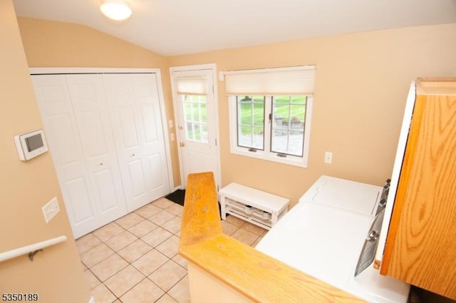 clothes washing area featuring light tile patterned floors, laundry area, and washer and dryer