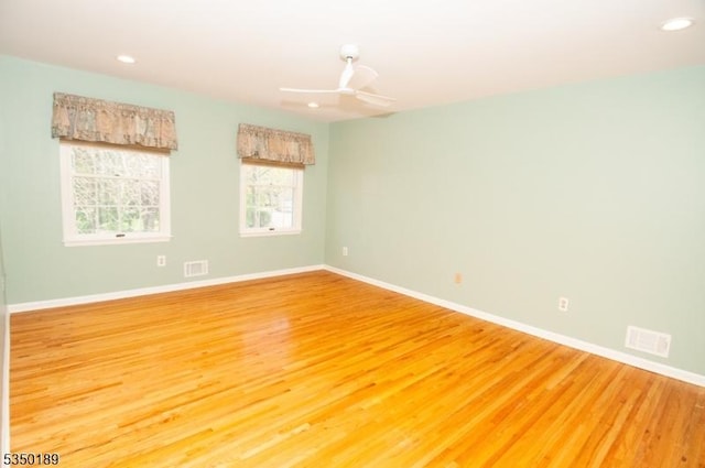 spare room with recessed lighting, baseboards, light wood-type flooring, and visible vents