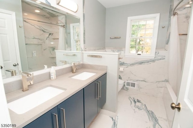 bathroom featuring double vanity, a marble finish shower, a sink, and marble finish floor