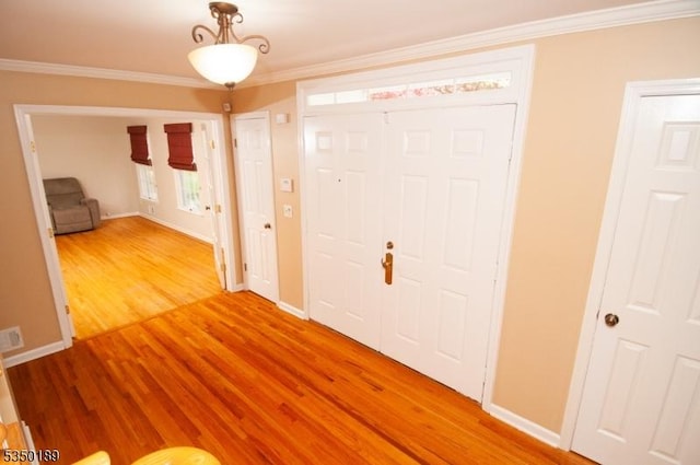 entrance foyer featuring crown molding, baseboards, and wood finished floors