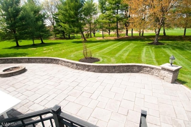 view of community with a lawn, a patio area, and an outdoor fire pit