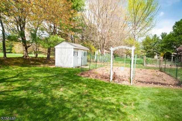 view of yard featuring fence, an outbuilding, and a shed