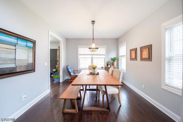 dining area featuring dark wood-type flooring, baseboards, and a wealth of natural light