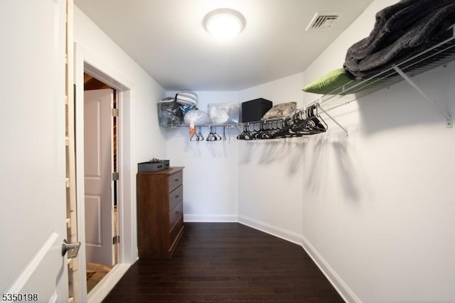 walk in closet with visible vents and dark wood-style flooring
