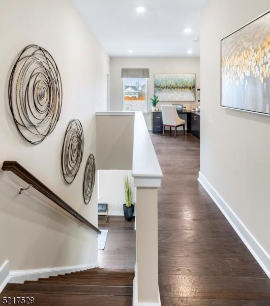 hall featuring dark wood-type flooring, baseboards, an upstairs landing, and recessed lighting