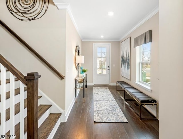 entrance foyer with a wealth of natural light, stairs, dark wood-type flooring, and ornamental molding