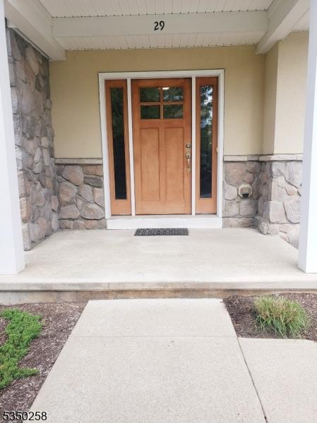 entrance to property featuring stucco siding and stone siding