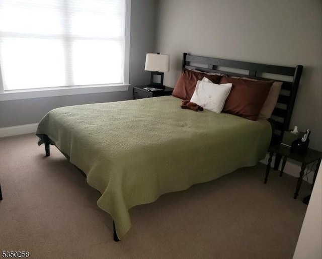 carpeted bedroom featuring baseboards