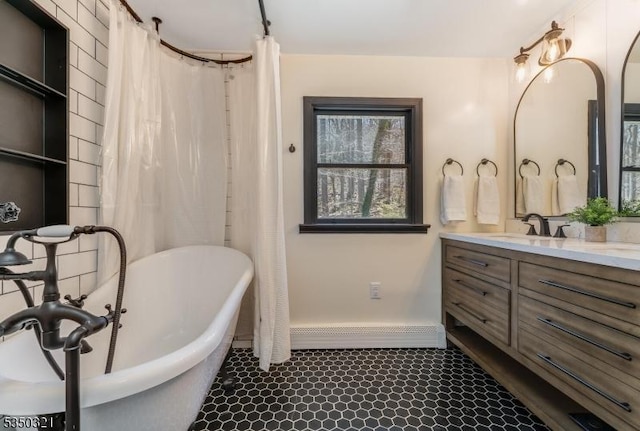 bathroom with a freestanding tub, baseboards, baseboard heating, and vanity