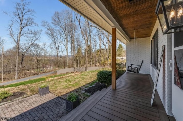 deck featuring a yard and covered porch