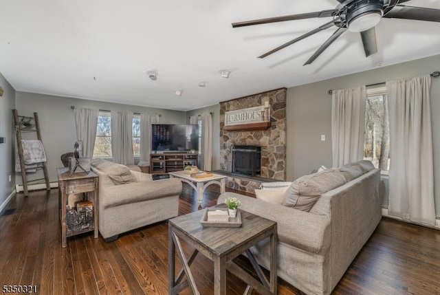 living area with dark wood-type flooring, a healthy amount of sunlight, baseboard heating, and ceiling fan