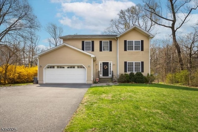traditional-style house with aphalt driveway, an attached garage, and a front yard