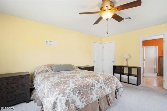 bedroom with visible vents, a ceiling fan, a closet, and light colored carpet