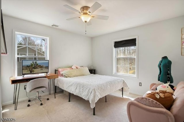 carpeted bedroom featuring visible vents, multiple windows, and baseboards