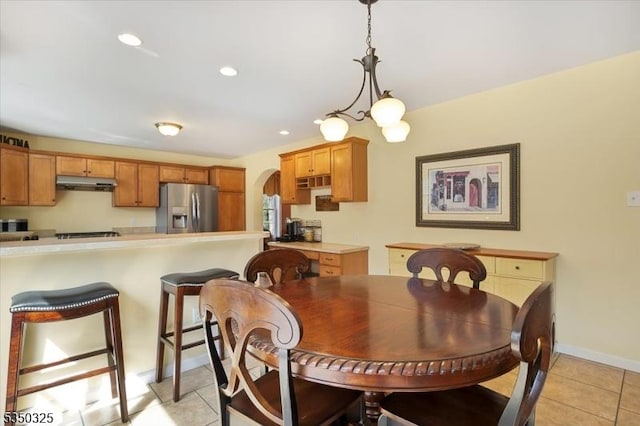 dining room featuring recessed lighting, arched walkways, light tile patterned floors, and baseboards