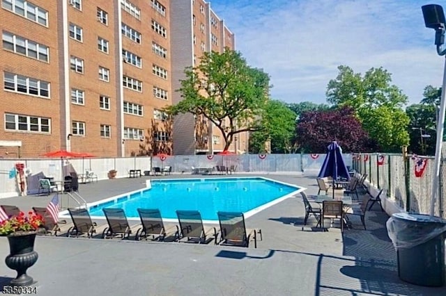 community pool featuring fence and a patio area
