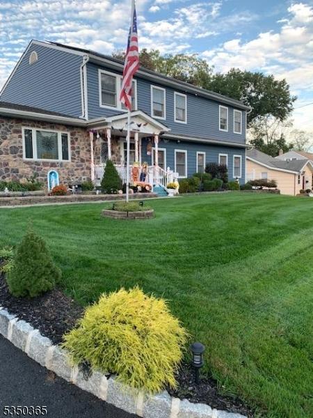 back of house featuring a yard and stone siding