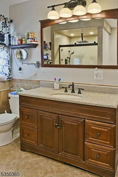 74 Longview Ave, Parsippany-Troy Hills Twp, NJ 07034 - full bathroom with vanity, a stall shower, tile patterned floors, and toilet