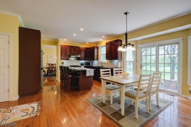 dining area featuring ornamental molding, light wood-style flooring, a chandelier, recessed lighting, and baseboards