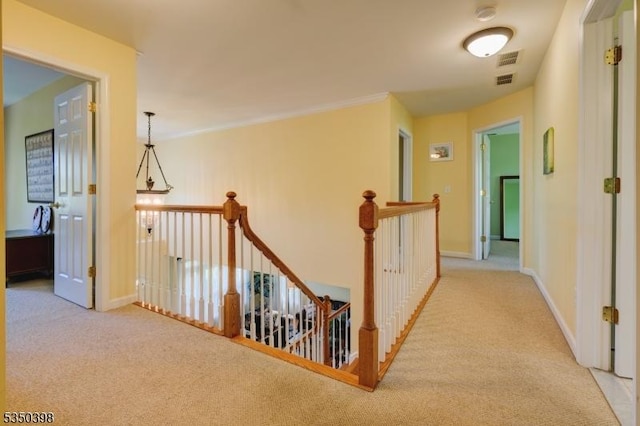 hallway with carpet flooring, an upstairs landing, and baseboards