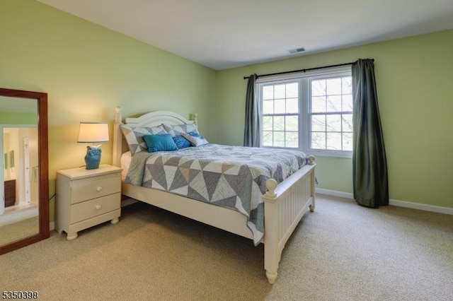 bedroom featuring light colored carpet and baseboards