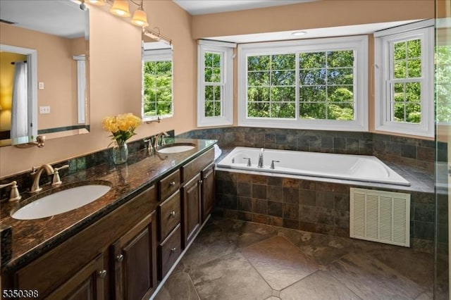 bathroom with a bath and double vanity