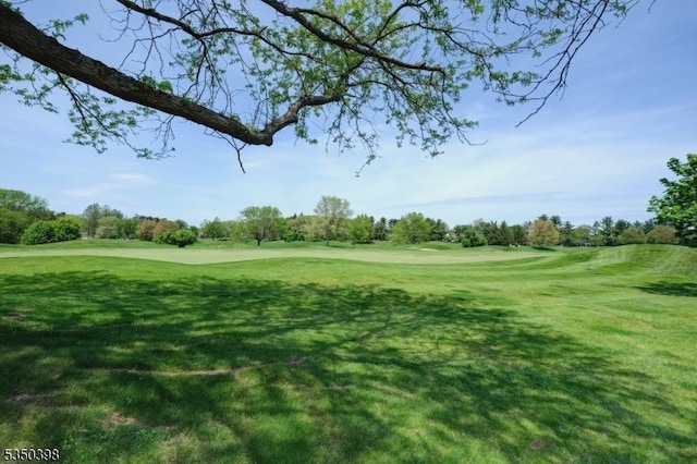 view of home's community with golf course view and a lawn
