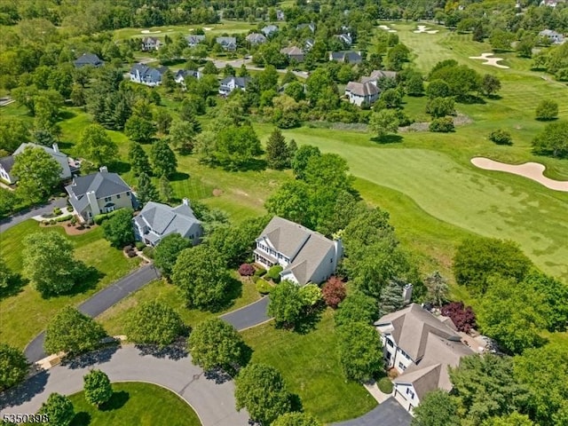 aerial view of residential area with a golf club and a tree filled landscape