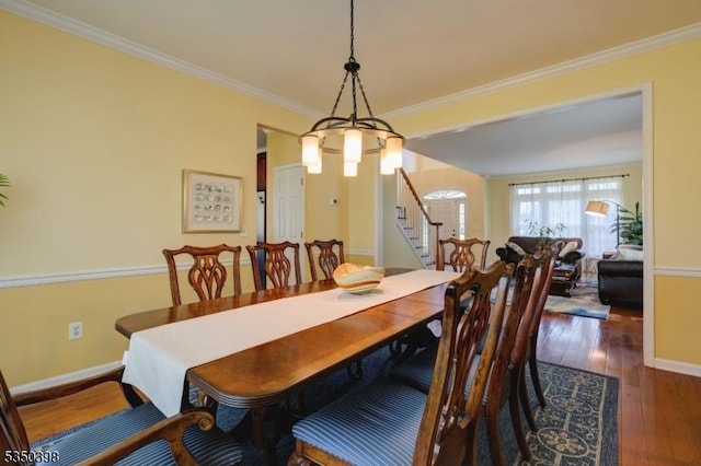 dining room with stairway, wood-type flooring, crown molding, and baseboards