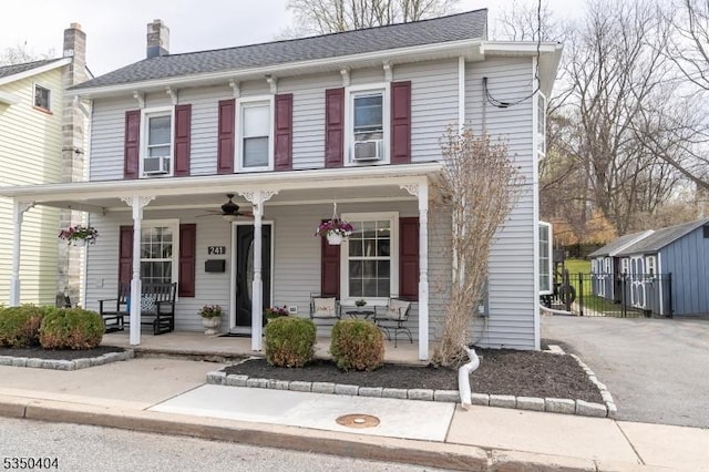 view of front of house featuring an outdoor structure, cooling unit, a porch, and ceiling fan