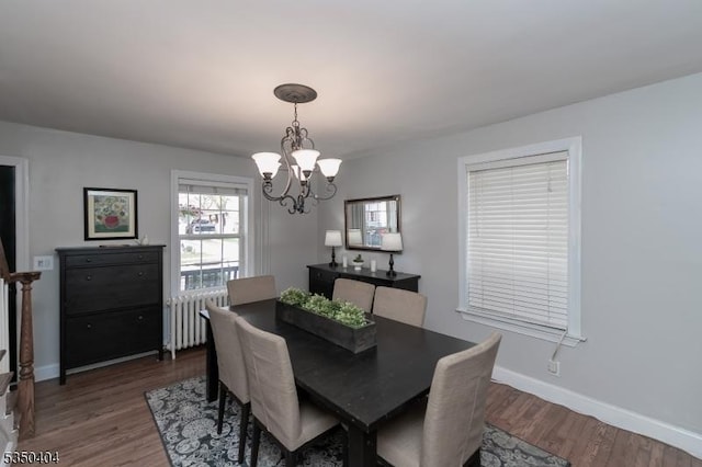 dining area featuring an inviting chandelier, radiator heating unit, dark wood-style floors, and baseboards