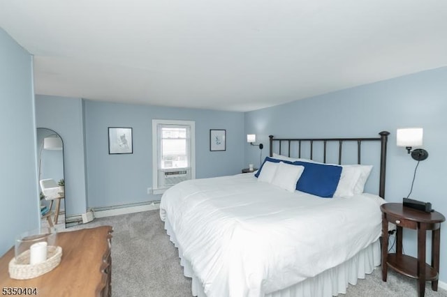 bedroom with a baseboard heating unit, baseboards, and light colored carpet