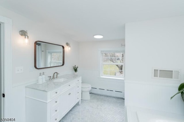 bathroom with baseboard heating, toilet, vanity, and visible vents
