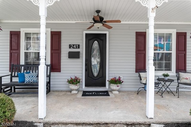 view of exterior entry with ceiling fan and covered porch