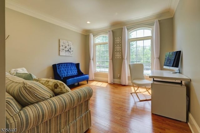 sitting room with crown molding, baseboards, and light wood finished floors