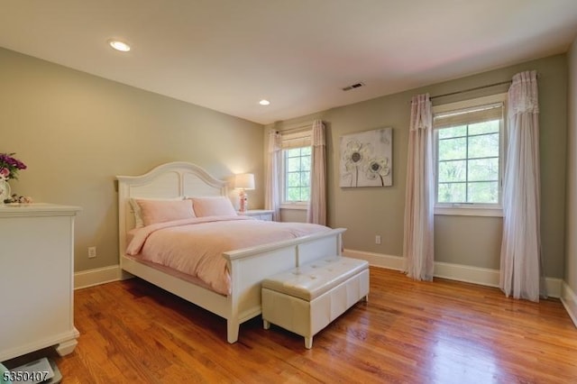 bedroom with light wood-style flooring, baseboards, visible vents, and recessed lighting