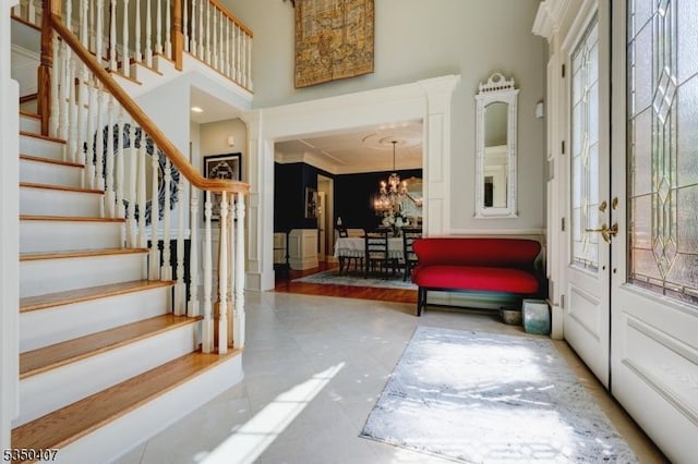 interior space featuring ornamental molding, stairway, a chandelier, and plenty of natural light