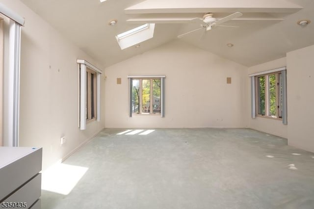 carpeted spare room with baseboards, ceiling fan, a healthy amount of sunlight, and lofted ceiling with skylight