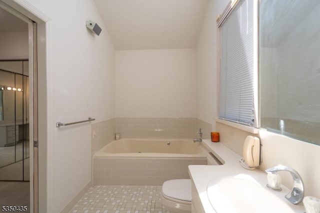 bathroom with a sink, a bath, and toilet