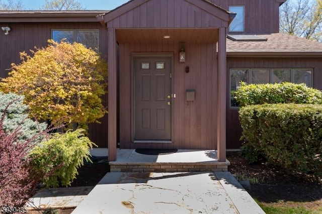 doorway to property featuring a shingled roof