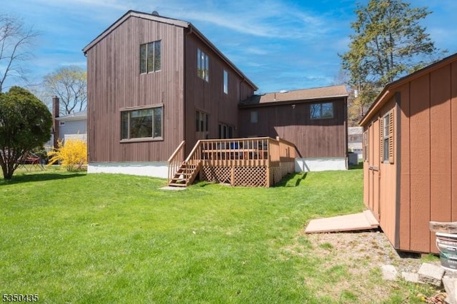 back of house featuring a wooden deck and a yard