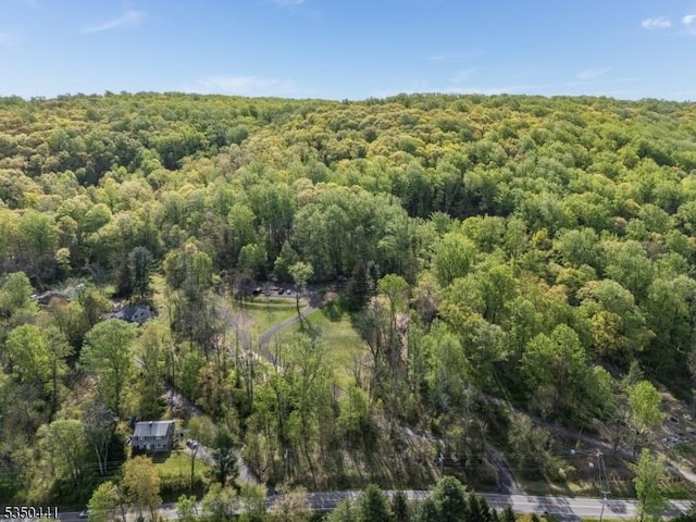 drone / aerial view featuring a wooded view
