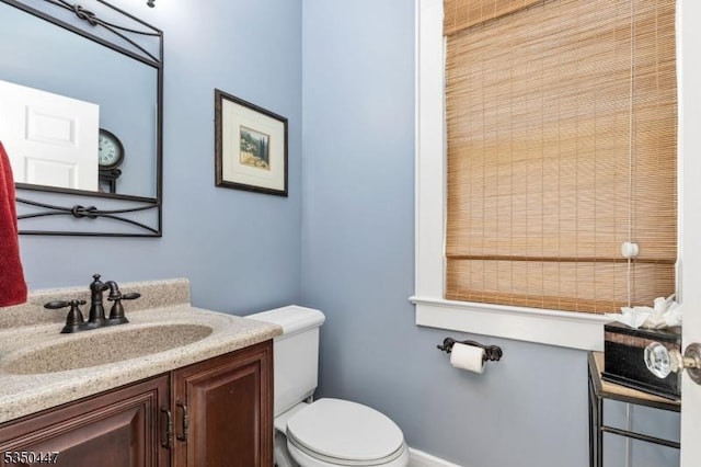 bathroom featuring vanity, baseboards, and toilet