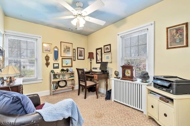 office space with light colored carpet, radiator, ceiling fan, and baseboards