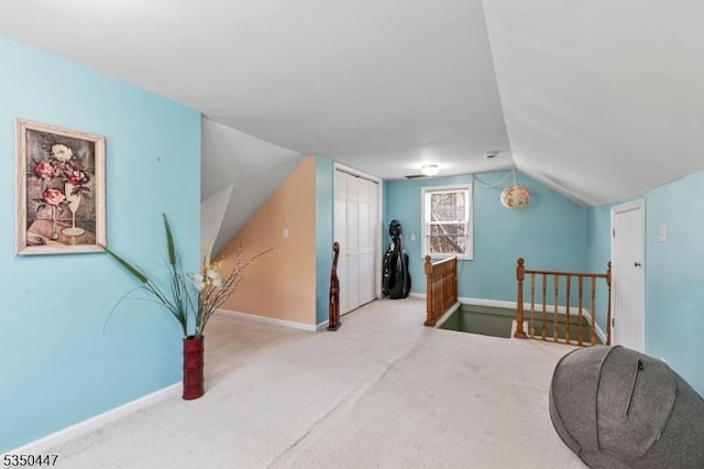 carpeted bedroom featuring baseboards, vaulted ceiling, and a closet