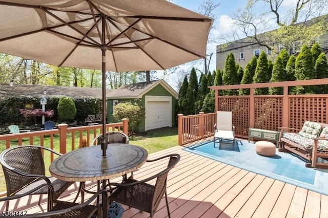 wooden deck featuring an outbuilding, outdoor dining area, and a yard