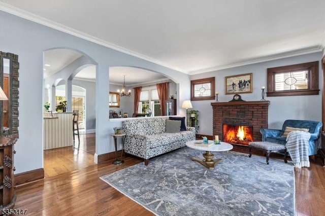 living room with baseboards, ornamental molding, and wood finished floors
